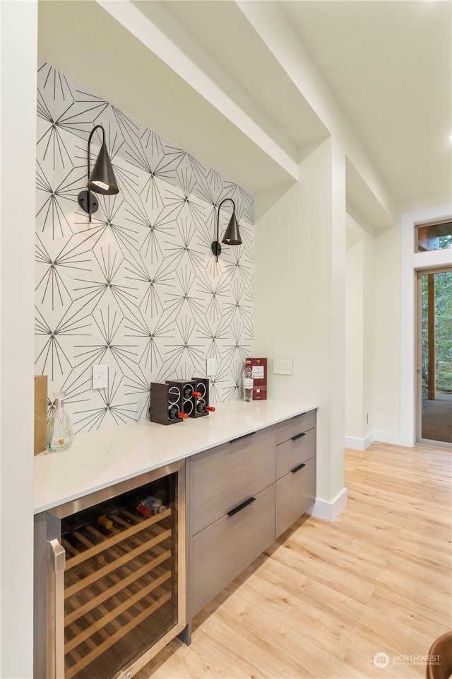 bar featuring light hardwood / wood-style flooring and wine cooler