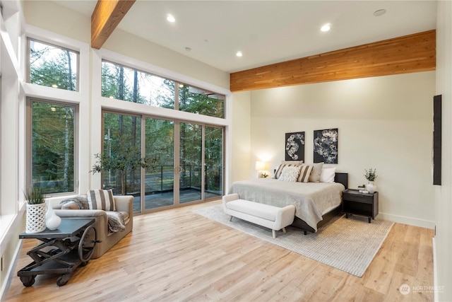 bedroom featuring beamed ceiling, access to exterior, and light wood-type flooring