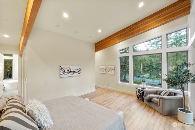 bedroom with lofted ceiling with beams, light hardwood / wood-style floors, and multiple windows