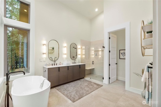 bathroom with vanity, shower with separate bathtub, a towering ceiling, and a wealth of natural light