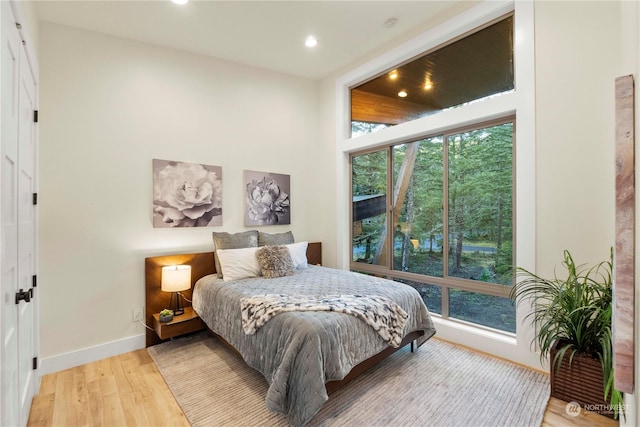 bedroom with light wood-type flooring and multiple windows