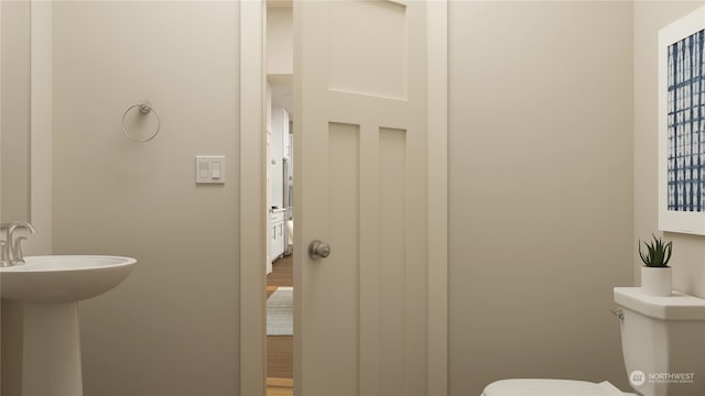 bathroom featuring sink, wood-type flooring, and toilet