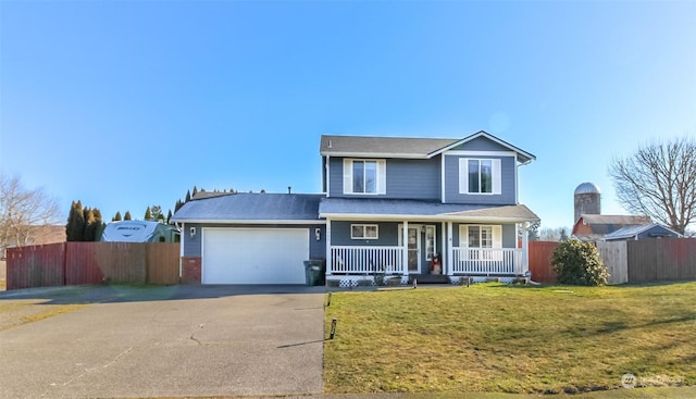 front of property with a garage, a front lawn, and covered porch