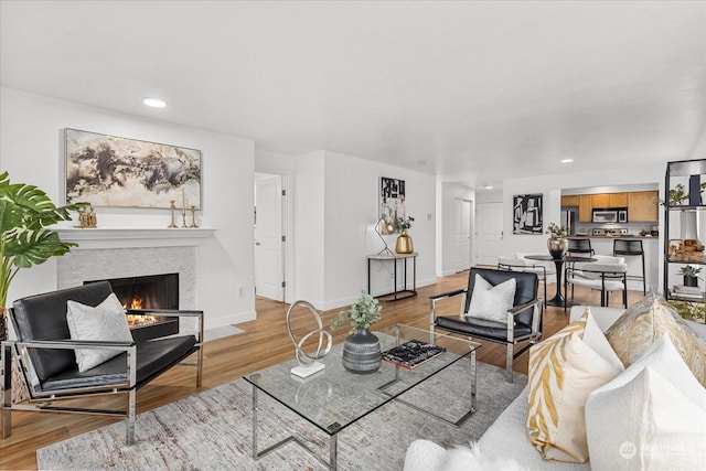 living room with light hardwood / wood-style flooring and a brick fireplace