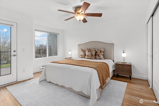 bedroom with access to outside, a baseboard heating unit, light hardwood / wood-style flooring, ceiling fan, and a closet