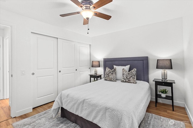 bedroom featuring ceiling fan, a closet, and light hardwood / wood-style floors