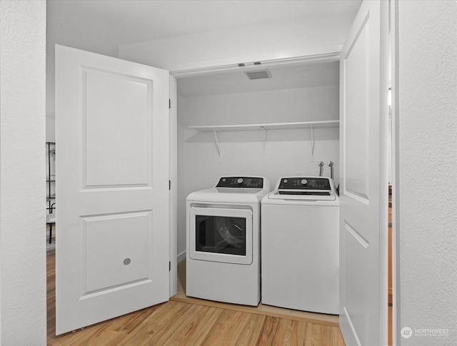 washroom featuring washer and dryer and light hardwood / wood-style floors