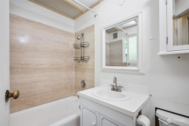 full bathroom featuring vanity, tiled shower / bath, and toilet