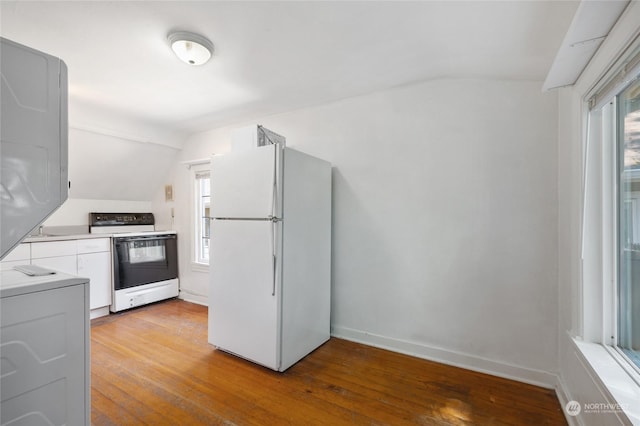 kitchen with white appliances, light hardwood / wood-style flooring, and vaulted ceiling