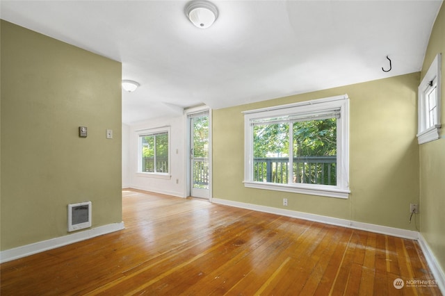 empty room with hardwood / wood-style floors and plenty of natural light