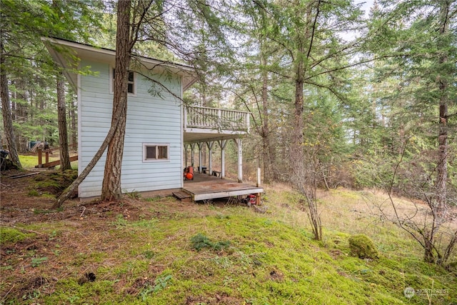 view of yard featuring a balcony and a deck