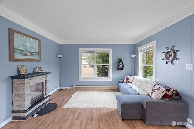 living room with a baseboard heating unit, a healthy amount of sunlight, crown molding, and light hardwood / wood-style flooring