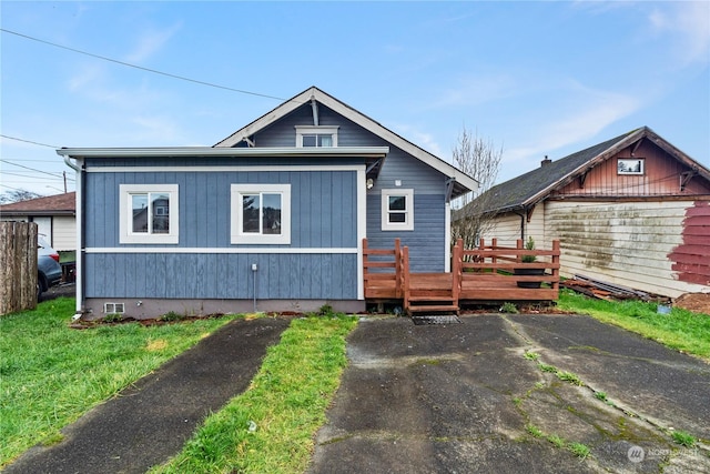 view of front of property with a wooden deck and a front lawn