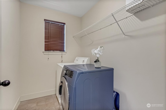 clothes washing area with washer and dryer and light tile patterned floors