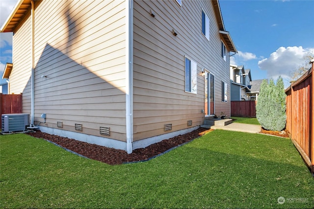 view of home's exterior with a yard and central AC unit