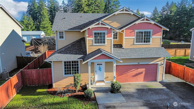 view of front of house with a front lawn, a garage, and central AC