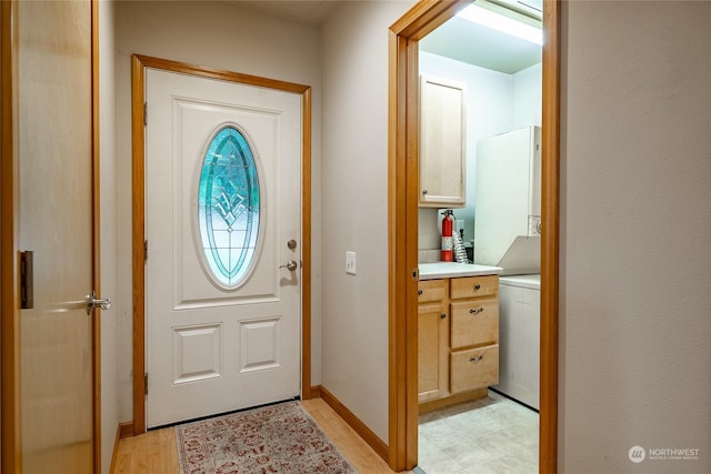 doorway featuring stacked washer / drying machine