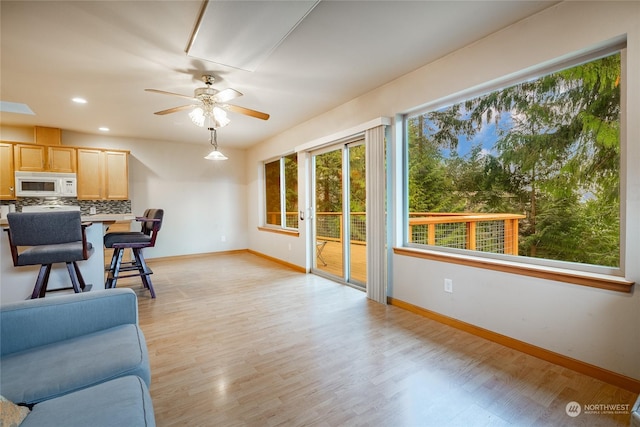 living room featuring ceiling fan and light hardwood / wood-style flooring