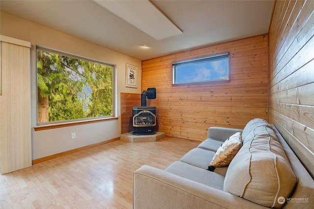 living room with a wood stove, light hardwood / wood-style flooring, and plenty of natural light