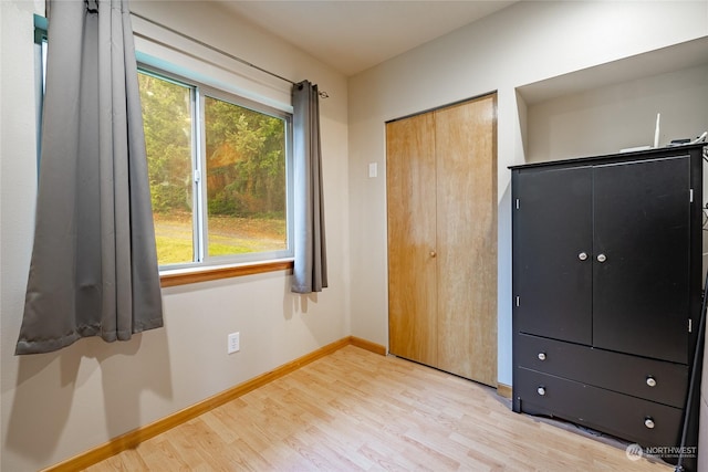 unfurnished bedroom featuring a closet and light wood-type flooring