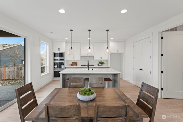 dining area with light wood-type flooring and sink