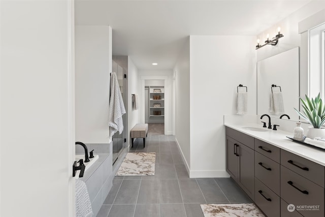 bathroom featuring tile patterned floors, plus walk in shower, and vanity