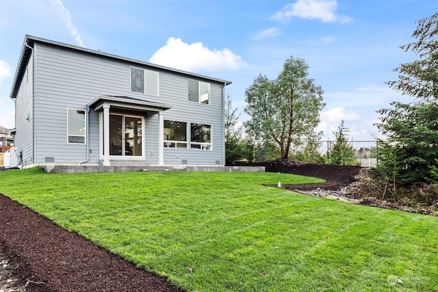 rear view of house featuring a lawn