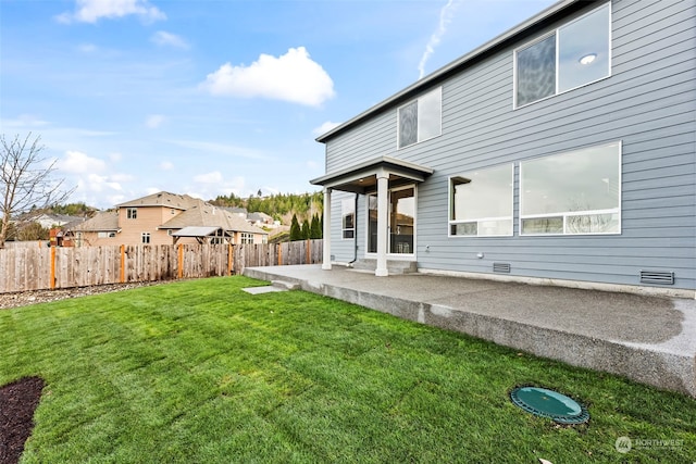 rear view of house with a lawn and a patio area