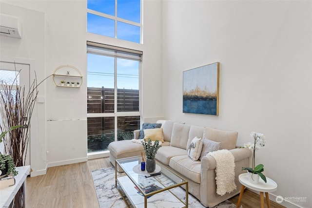 living room featuring light hardwood / wood-style flooring and an AC wall unit