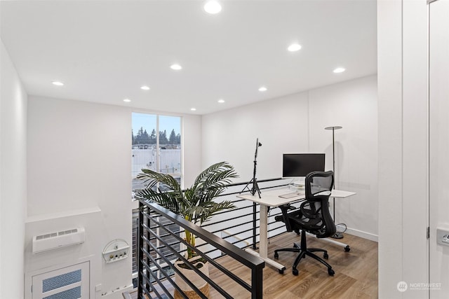 office area with a wall mounted AC and hardwood / wood-style floors