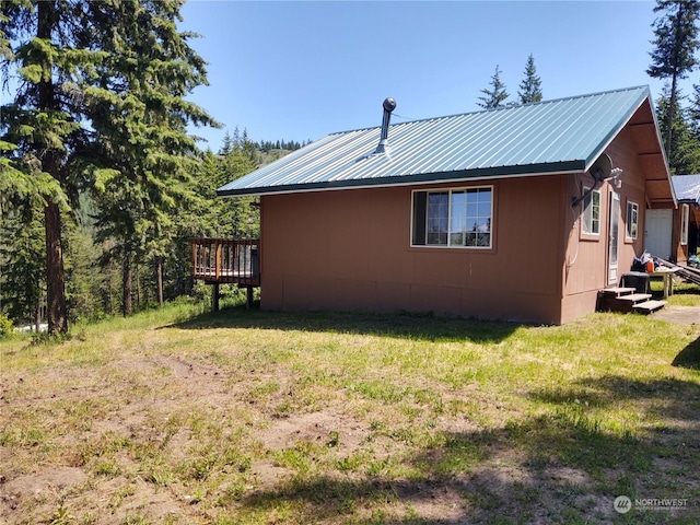 view of side of home with a yard and a wooden deck