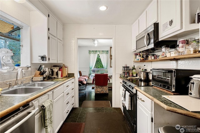 kitchen with appliances with stainless steel finishes, a sink, and white cabinetry