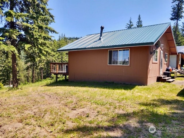 view of home's exterior with a yard and a wooden deck