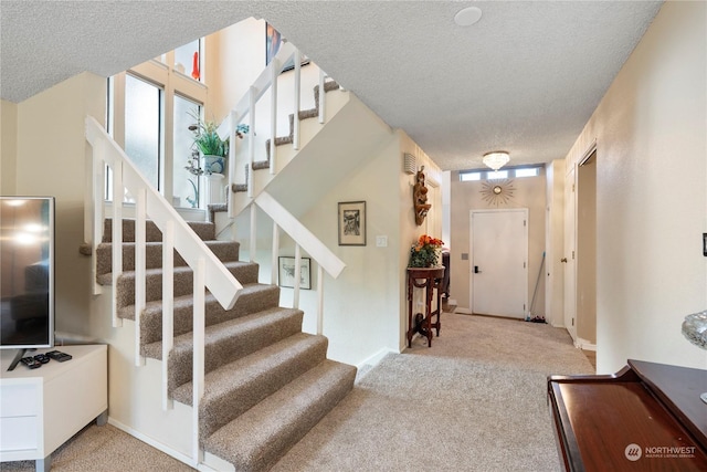 stairs featuring carpet and a textured ceiling