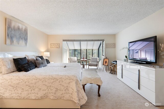 bedroom with light colored carpet and a textured ceiling