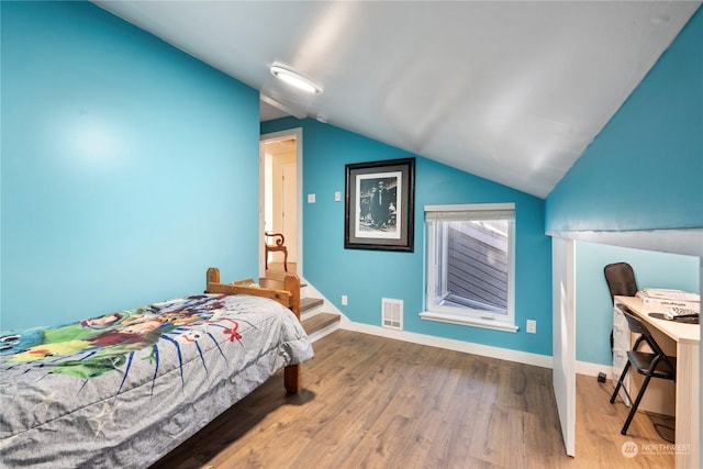 bedroom with hardwood / wood-style floors and lofted ceiling