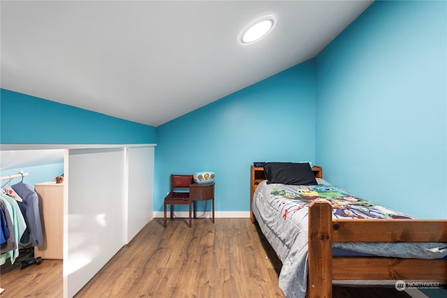 bedroom with wood-type flooring and lofted ceiling