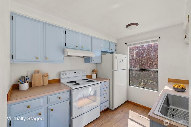 kitchen with white appliances, light wood-type flooring, under cabinet range hood, light countertops, and blue cabinetry