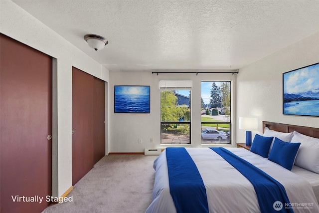 carpeted bedroom featuring a textured ceiling, baseboards, and baseboard heating