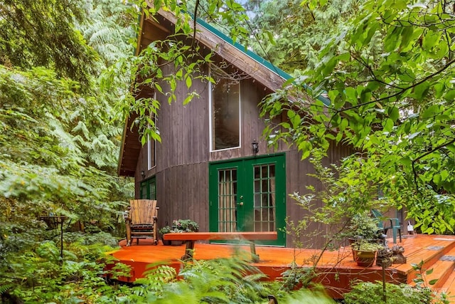 view of side of home with french doors and a deck