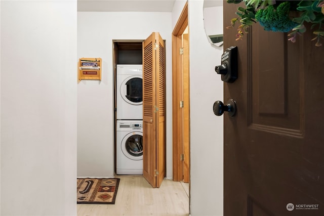 laundry room with stacked washer and clothes dryer and light wood-type flooring