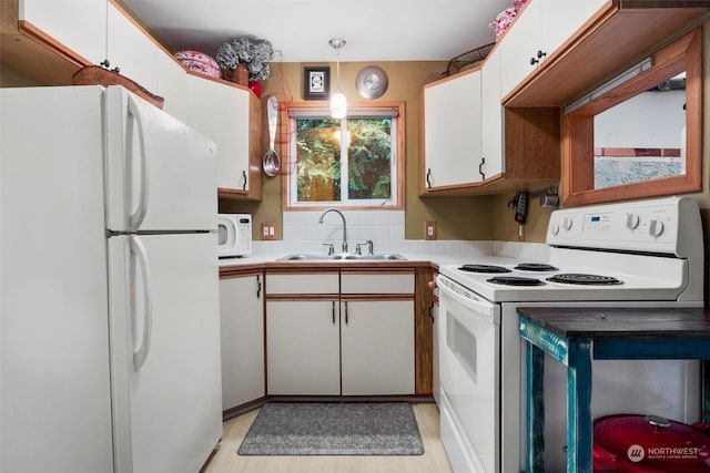 kitchen with backsplash, white appliances, sink, and white cabinets