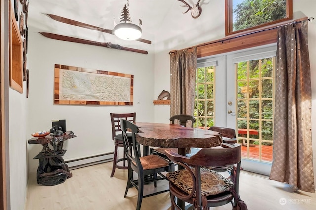 dining room with vaulted ceiling, a baseboard heating unit, light hardwood / wood-style flooring, and french doors