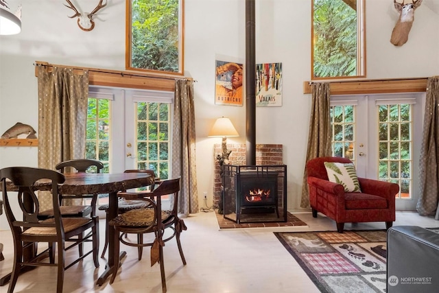 living area featuring a towering ceiling, french doors, and a healthy amount of sunlight