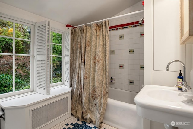 bathroom with tile patterned flooring, shower / tub combo, radiator, and sink