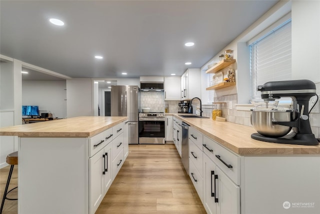 kitchen with white cabinetry, sink, a breakfast bar area, and stainless steel appliances