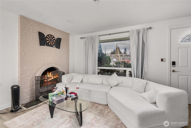 living area featuring a brick fireplace and wood finished floors