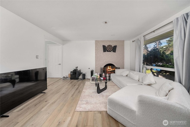 living area featuring light wood-type flooring and a fireplace