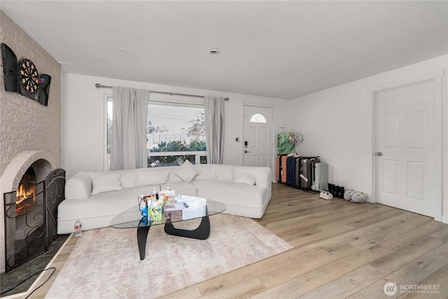 living area featuring a brick fireplace and wood finished floors