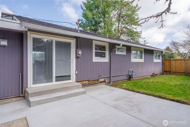 view of front of property with entry steps, fence, a patio, and a front yard